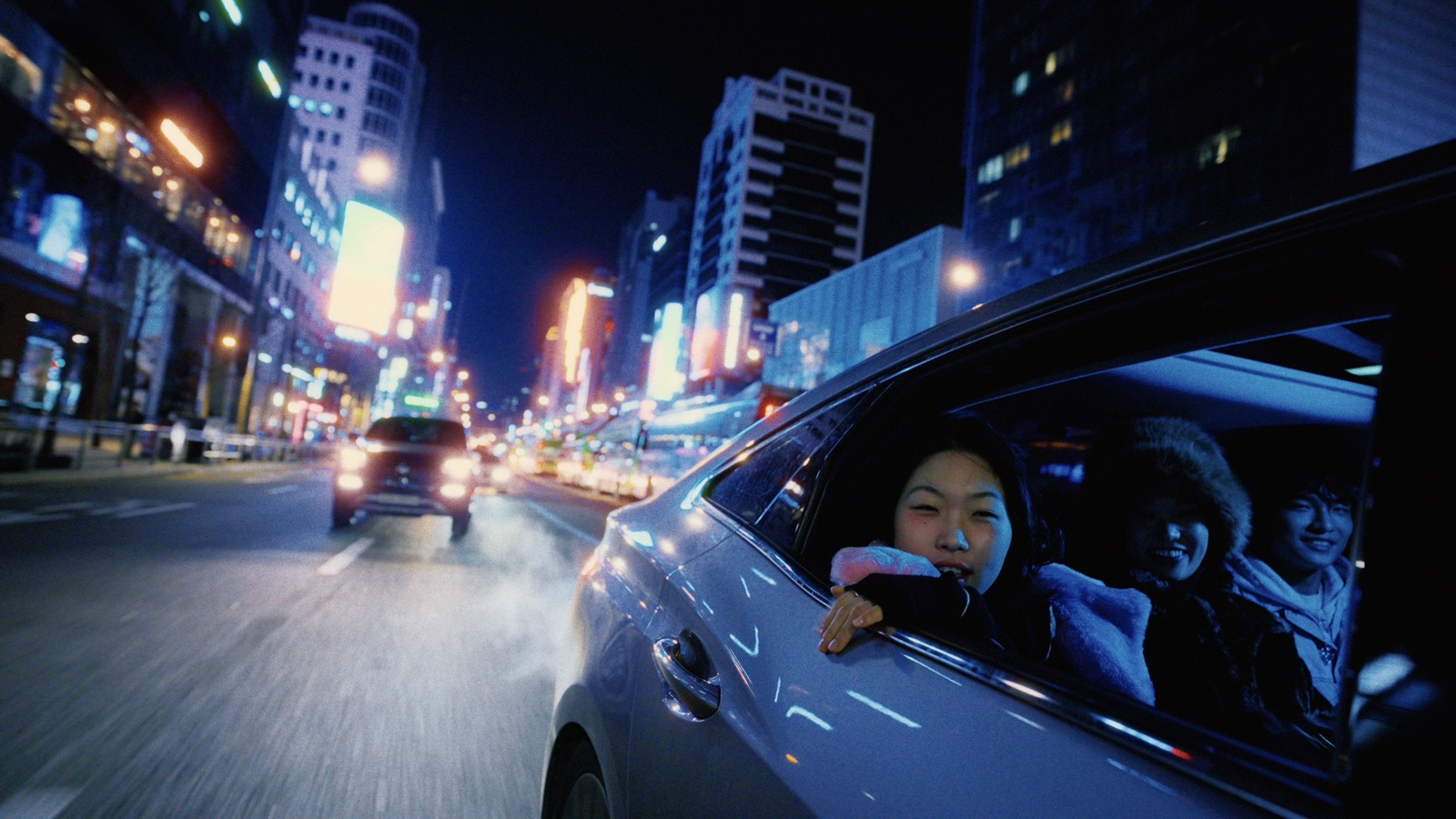 A night street from a car window, with halation around the lights
